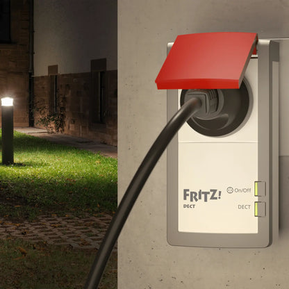 FRITZ!DECT 210 an Wandsteckdose eingesteckt, Blick in beleuchteten Garten