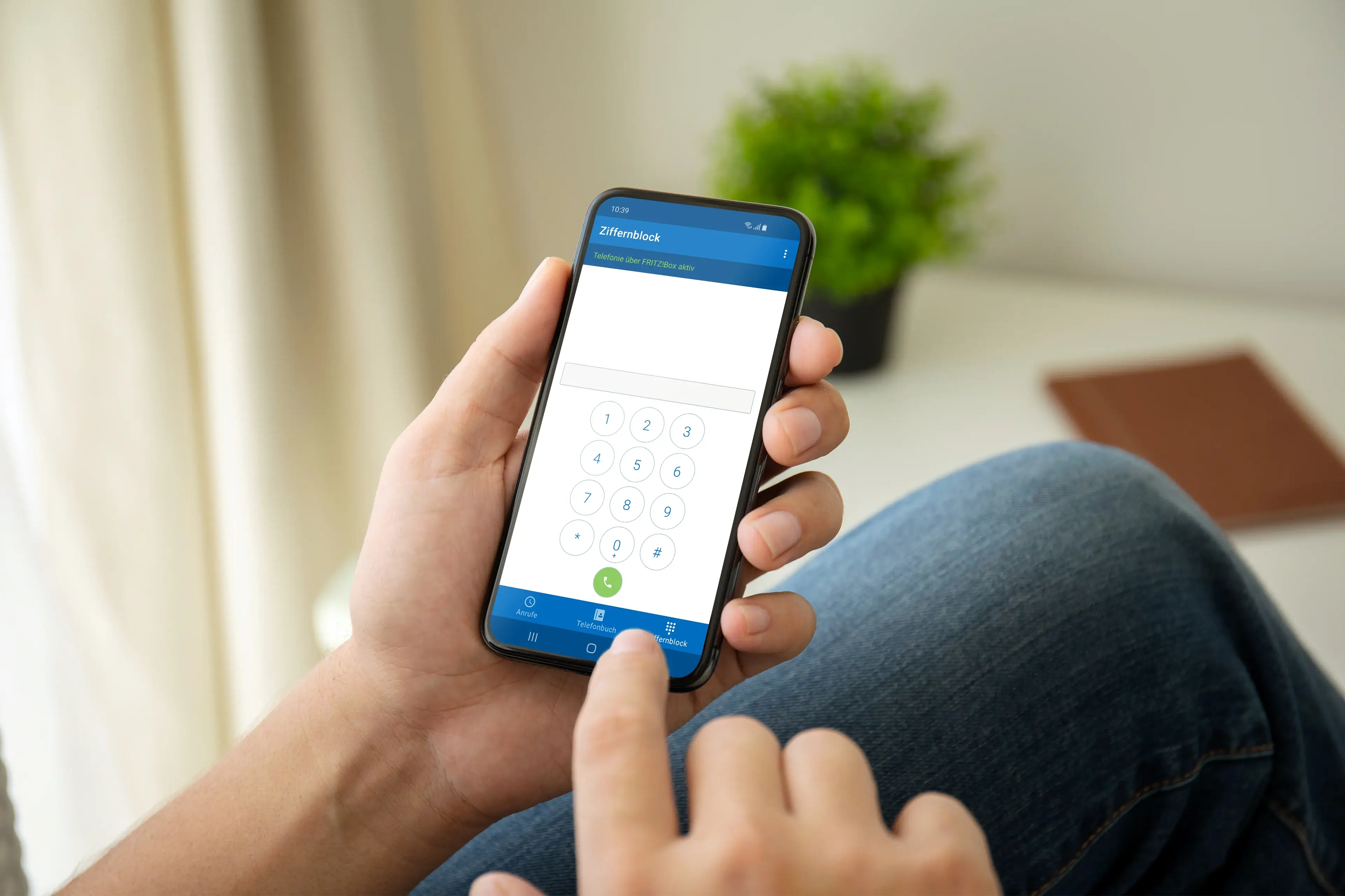 Person hält ein Smartphone mit einer digitalen Tastatur, bereit zum Wählen oder Eingeben von Informationen.